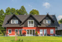 Farbenfrohes Einfamilienhaus mit vielen Satteldachgauben und Reformziegel Z10 im trendigen altschwarz in der Gesamtansicht