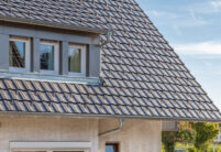 Altschwarzes Z10-Dach auf Einfamilienhaus am Hang mit Details auf den Dachziegel