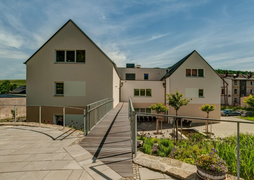 U-förmiges Wohnhaus mit Großflächenziegel Z10 in altschwarz auf den Satteldächern mit Holzsteg und schönem Innenhof