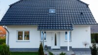 Klassisches Einfamilienhaus mit Krüppelwalmdach und Reformziegel Z10 in altschwarz