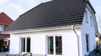 Klassisches Einfamilienhaus mit Krüppelwalmdach und Reformziegel Z10 in altschwarz fotografiert aus der hinteren Ansicht