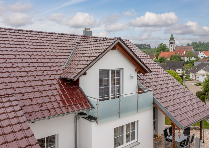 Z10 Dachfläche in edelweinrot auf Einfamilienhaus. Im Bild Gaube mit Balkon.