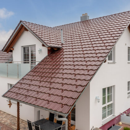 Z10 Dachfläche in edelweinrot auf Einfamilienhaus mit Schneenasen auf Schleppdach.
