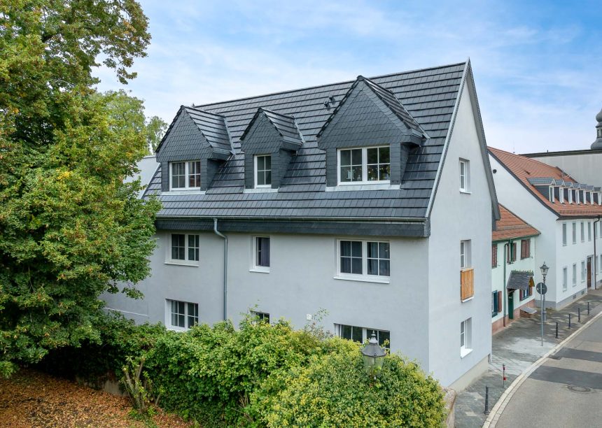 Sanierungsobjekt mit zwei Vollgeschossen mit Jacobi Solarziegel Stylist-PV in edelspacegrau auf Satteldach mit vielen Gauben