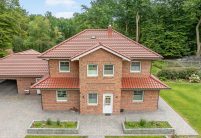 J11v in toskanarott matt auf Klinkeranwesen mit Fußwalm in der Gesamtansicht