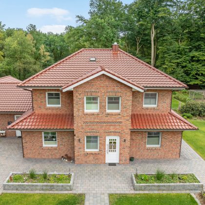 J11v in toskanarott matt auf Klinkeranwesen mit Fußwalm in der Gesamtansicht