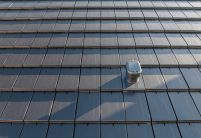 Dachziegel Stylist in edelschiefer mit Fokus auf den Sanilüfter. Der Flachziegel ist in Reihe verlegt