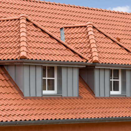 Hohlfalzziegel in naturrot auf Mehrfamilienahus mit Blick auf die Gauben