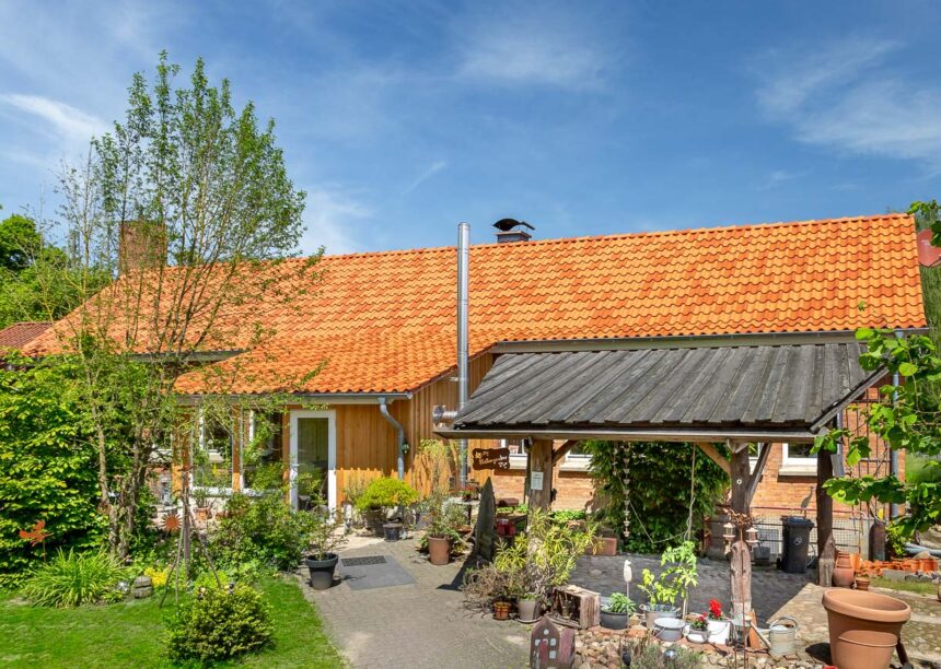 Naturrote und altrote Z5 auf idyllischem Klinkerhaus mit Bildfokus auf den Hauseingang