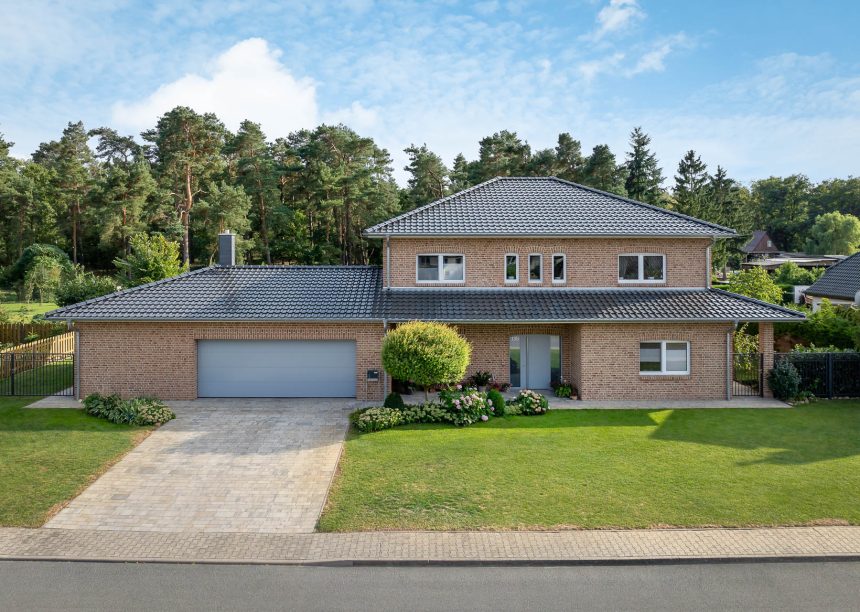 J11v in spacegrau auf Walmdach mit Fußwalm - mit Klinkerfassade und schöner Grünanlage