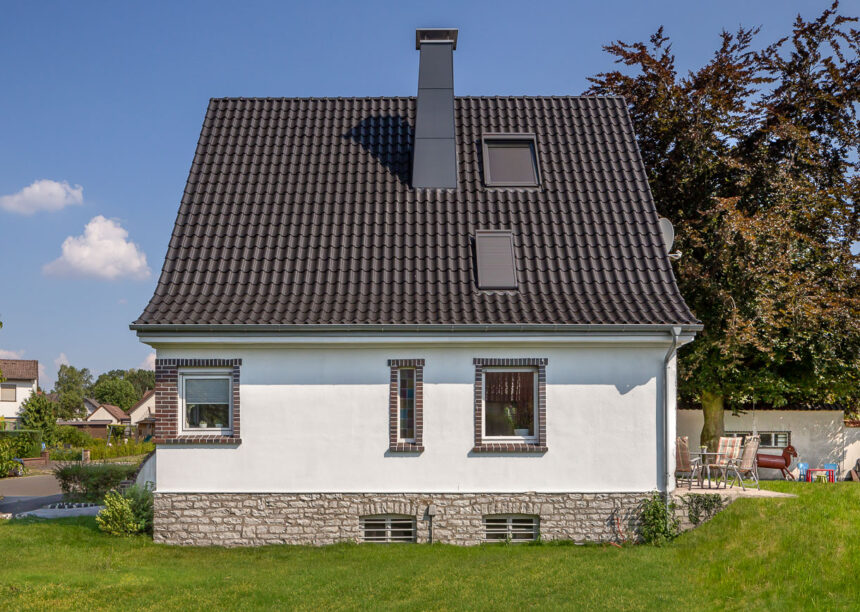 Steildach auf saniertem Haus mit Dachziegel Z5 in altschwarz in der seitlichen Ansicht aus der Gartenansicht