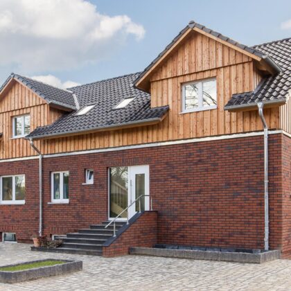 Inspirierender Mix mit Holz und Klinker und Z5-Dach in altschwarz