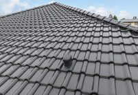 Stilvoller Bungalow mit Dachziegel J11v von Jacobi in edelschwarz mit Details vom nichtkeramischen Zubehör Sanitärlüfter