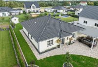 Gesamtansicht von Bungalow mit Carport und Hofeinfahrt sowie Walmdach mit Walmkappen und Dachziegel J11v und Firstziegel F6v