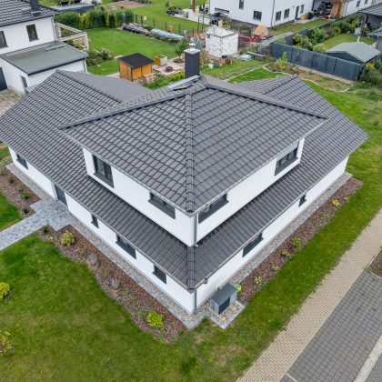 Aus der Luft fotografiert: Turm an L-Bau; Neubau mit auffälliger Form und Dachziegel J11v im modernen schwarzton