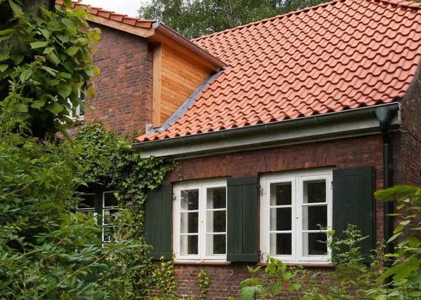 Z5 in altrot auf schön saniertem Klinker-Wohnhaus mit Fokus auf die Kehle und Holzverkleidung an der Satteldachgaube