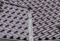 Stilvoller Bungalow mit maronenbraunen Dachziegel auf dem Walmdach mit Fokus auf die Dachkehle
