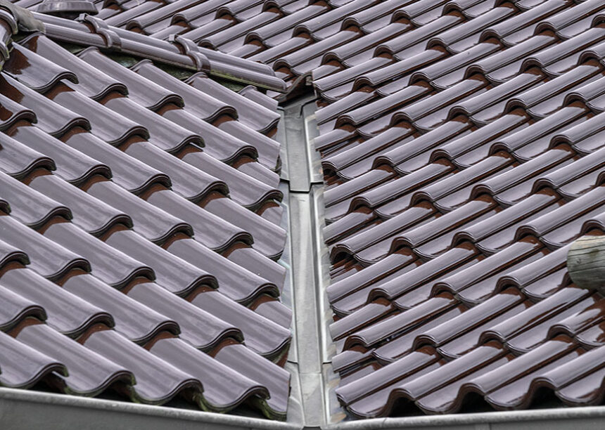 Stilvoller Bungalow mit maronenbraunen Dachziegel auf dem Walmdach mit Fokus auf die Dachkehle