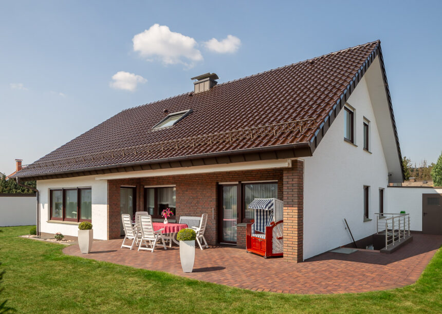 Maronenbrauner Dachziegel Z5 auf saniertem Einfamilienhaus mit Blick auf die Terrasse und Balkon