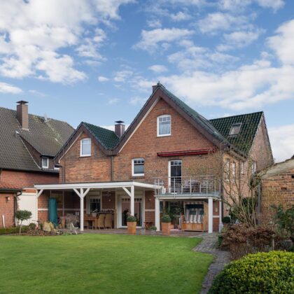 Klinkerhaus mit tannengrünem Dachziegel Z5 in der Gesamtansicht mit Terrasse