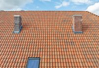 Denkmalgeschütztes Haus mit Krüppelwalmdach und Z5 in rot-bunt gedämpft mit schönem Schwung am Dach, gedeckt von Schwarz Holzbau