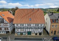 Komplette Ansicht von Denkmalgeschütztem Haus mit Krüppelwalmdach und Z5 in rot-bunt gedämpft