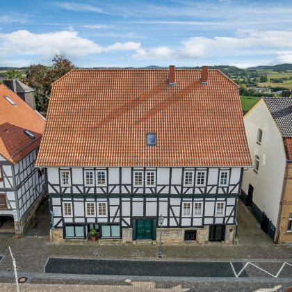 Komplette Ansicht von Denkmalgeschütztem Haus mit Krüppelwalmdach und Z5 in rot-bunt gedämpft