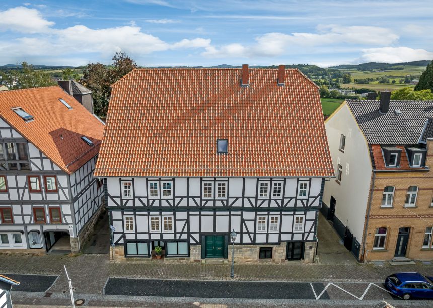 Komplette Ansicht von Denkmalgeschütztem Haus mit Krüppelwalmdach und Z5 in rot-bunt gedämpft