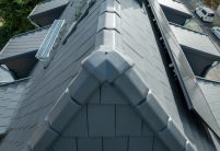 Eine top Referenz von Jacobi Dachziegel mit modernem Dachziegel Stylist in edelschiefer, besonderer Grauton mit dem keramischen Zubehör 3achsige Walmkappe passend zur Firstreihe F6v
