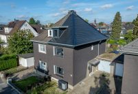 Steildach von Doppelhaus mit Solarziegel von Jacobi im Vergleich zur nicht sanierten Haushälfte in der Gesamtansicht