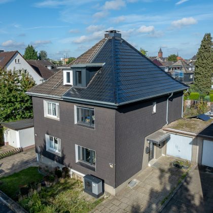 Steildach von Doppelhaus mit Solarziegel von Jacobi im Vergleich zur nicht sanierten Haushälfte in der Gesamtansicht