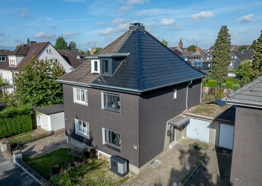 Steildach von Doppelhaus mit Solarziegel von Jacobi im Vergleich zur nicht sanierten Haushälfte in der Gesamtansicht