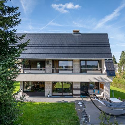 Einfamilienhaus mit Flachziegel Stylist in edelspacegrau mit Garteneinblick