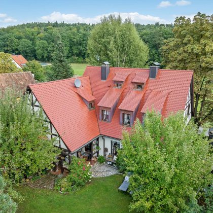 Aus der Vogelperspektive Fachwerkhaus mit Biberdach im Segmentschnitt in der Oberfläche edelrosso