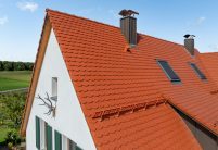 Biberdach in rotbraun mit Schneefanggitter auf besonderer Dachform mit Details vom Ortgang und Giebel