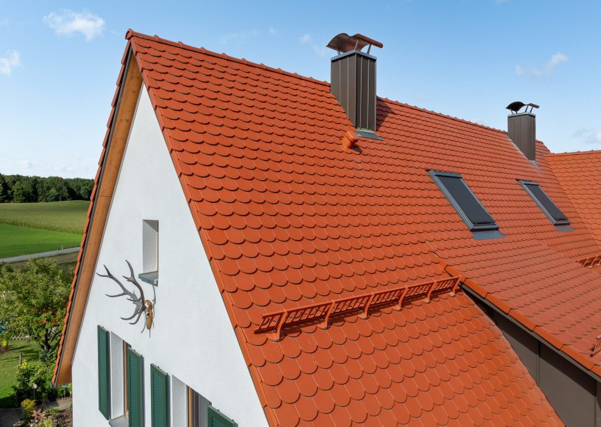 Biberdach in rotbraun mit Schneefanggitter auf besonderer Dachform mit Details vom Ortgang und Giebel