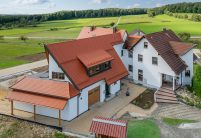 Biberdach in rotbraun mit Schneefanggitter auf besonderer Dachform mit Carport