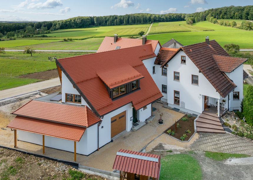 Biberdach in rotbraun mit Schneefanggitter auf besonderer Dachform mit Carport