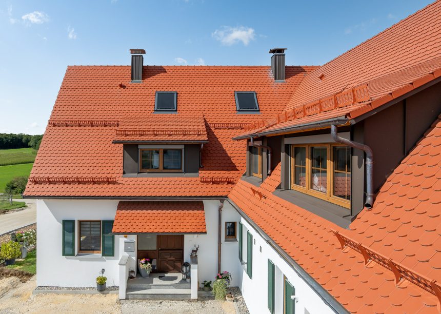 Biberdach in rotbraun mit Schneefanggitter auf besonderer Dachform