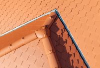 Dach mitten in der Stadt mit Jacobi Biber Rundschnitt in naturrot mit Details vom First und 3achsige Walmkappe