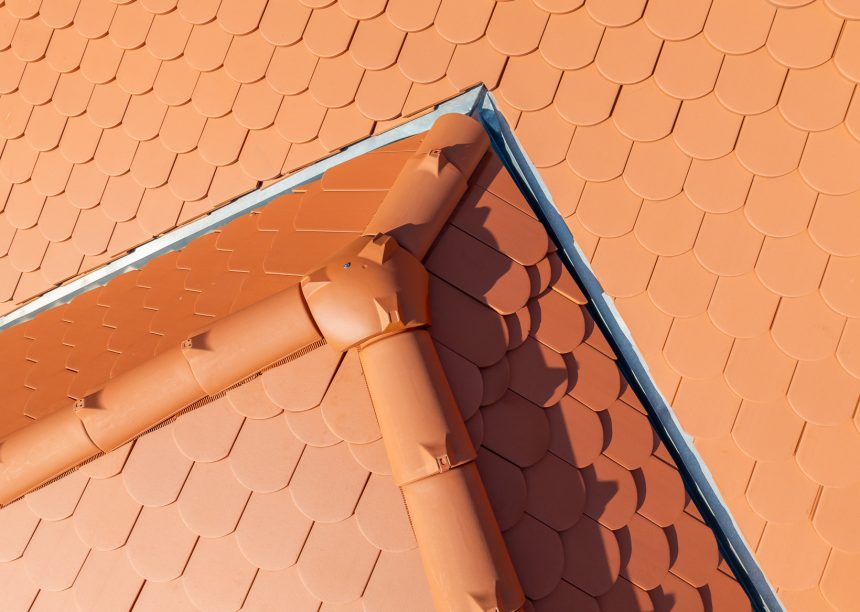 Dach mitten in der Stadt mit Jacobi Biber Rundschnitt in naturrot mit Details vom First und 3achsige Walmkappe