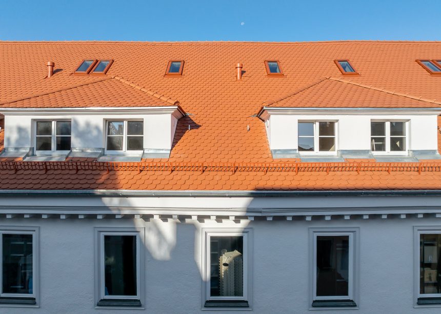 Dach mitten in der Stadt mit Jacobi Biber Rundschnitt in naturrot hier mit Gauben und Faasade