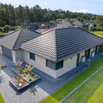 Großfalzziegel Z10 in edelschwarz auf Klinkerbungalow, Firstziegel F6v, und 3achsige Walmkappe in der gesamten Ansicht - schräge Vogelperspektive