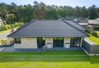 Großfalzziegel Z10 in edelschwarz auf Klinkerbungalow, Firstziegel F6v, und 3achsige Walmkappe in der gesamten Ansicht von der Nordseite fotografiert