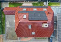 Klinkerhaus mit Krüppelwalmdach gedeckt mit Jacobi Dachziegel J11v im besonderen Rotton edelkupfer aus der Vogelperspektive per Drohne