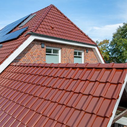 Klinkerhaus mit Krüppelwalmdach gedeckt mit Jacobi Dachziegel J11v im besonderen Rotton edelkupfer