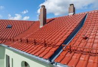 W6v in edelmarone auf sanierter Stadt-Mehrfamilienhaus mit Schneefangsystem von Jacobi farblich passendes Zubehör