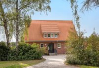 Aus der Frontalansicht fotografiert: Jugendtreff mit Dachziegel Doppelmulde Z2 in naturrot, verklinkerte Fassade mit Satteldach