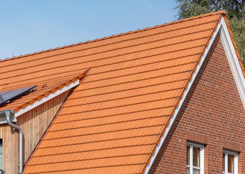 Giebel mit Firstanfänger und Ortgängen re/li im Bildfokus und Dachziegel Doppelmulde Z2 in naturrot auf Jugrendtreff verklinkerten Fassade