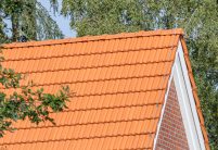 Giebel mit Firstanfänger und Ortgängen re/li im Bildfokus und Dachziegel Doppelmulde Z2 in naturrot auf Jugendtreff